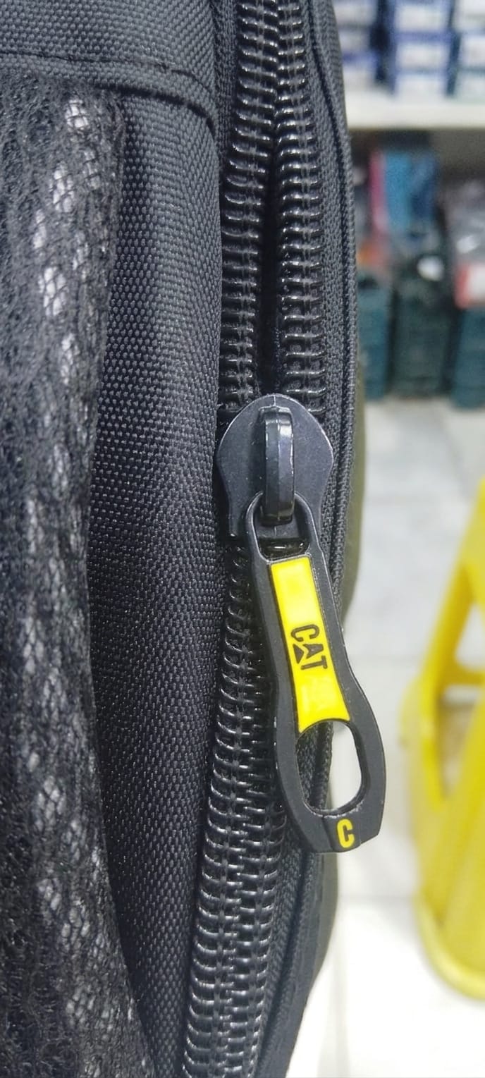 Close-up of a black zippered pouch with a yellow logo on a blurred background