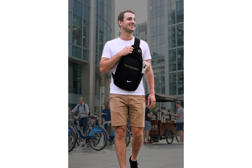 Man walking outdoors with a black bag, urban setting